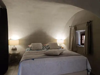 a bedroom with a large bed with two lamps at PARFUMU DI MACHJA in Santa-Lucia-di-Mercurio
