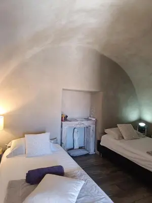 two beds in a room with an arched ceiling at PARFUMU DI MACHJA in Santa-Lucia-di-Mercurio
