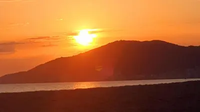 a sunset over the ocean with a mountain at Porticcio - Casa Corsa in Porticcio