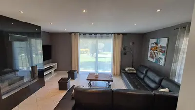 a living room with a couch and a television at Très belle villa piscine jacuzzi grande propriété 10 pers in Belgodère