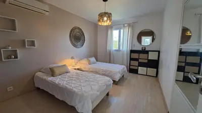 a bedroom with two beds and a mirror at Très belle villa piscine jacuzzi grande propriété 10 pers in Belgodère