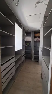 a walk in closet with gray shelves and a white ceiling at Très belle villa piscine jacuzzi grande propriété 10 pers in Belgodère
