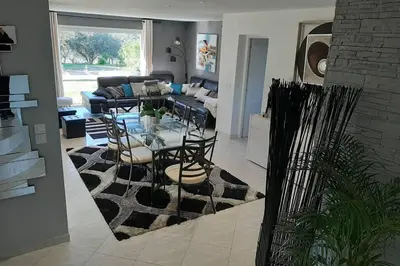 a living room with a table and a couch at Très belle villa piscine jacuzzi grande propriété 10 pers in Belgodère