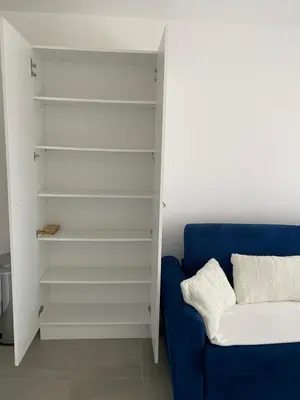a living room with a blue couch and shelves at Stella mare à porticcio in Porticcio