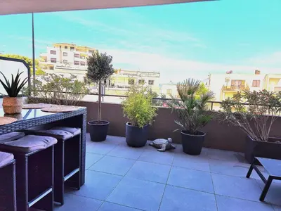 a teddy bear sitting on a balcony with potted plants at T2 de standing front de mer in Propriano