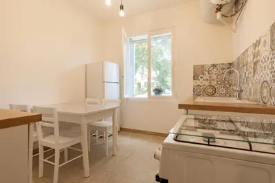 a kitchen with a table and a table and a stove at Résidence Poggiole in San-Nicolao