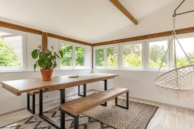 a dining room with a table and a swing at Résidence Poggiole in San-Nicolao