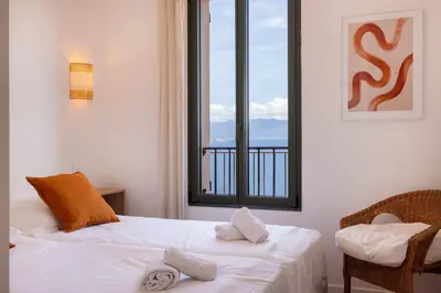 a bedroom with a bed and a window with a view at Résidence Eole in Cargèse