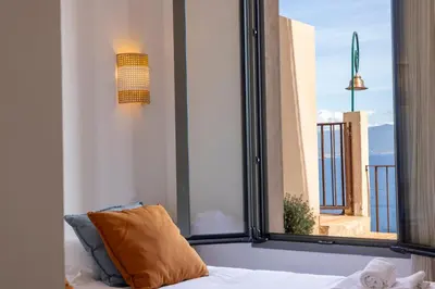 a bed with a pillow in a room with windows at Résidence Eole in Cargèse