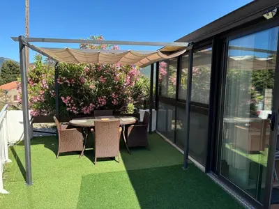 a patio with a table and chairs on a balcony at Appartement au calme à 15 minutes de Sartène in Foce