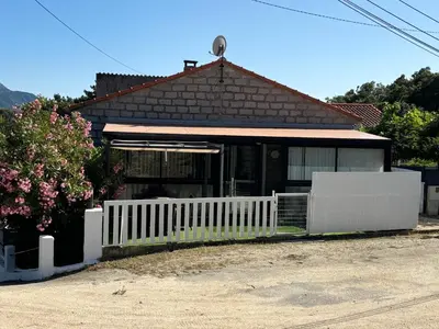 a house with a white fence in front of it at Appartement au calme à 15 minutes de Sartène in Foce