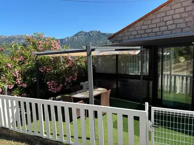 a patio with a white fence and an umbrella at Appartement au calme à 15 minutes de Sartène in Foce