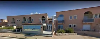 a large apartment building with a large window at Studio situé à 20 metres de la plage d Agosta Porticcio in Albitreccia