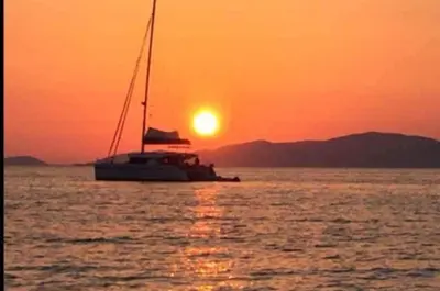 a sail boat in the ocean at sunset at Studio situé à 20 metres de la plage d Agosta Porticcio in Albitreccia