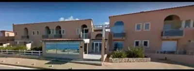 a large building with a glass door in front of it at Studio situé à 20 metres de la plage d Agosta Porticcio in Albitreccia