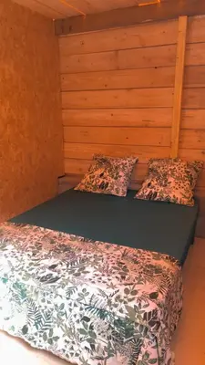 two beds in a room with wooden walls at Cabane 2 in Olivese