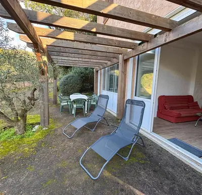 a patio with chairs and a table and a red couch at Domaine Mare e Monti - T1 Le Maquis in Albitreccia