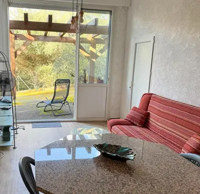 a living room with a red couch and a table at Domaine Mare e Monti - T1 Le Maquis in Albitreccia