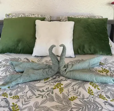 two swans laying on a bed with pillows at Domaine Mare e Monti - T1 Le Maquis in Albitreccia