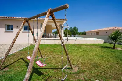 a wooden swing set in a yard at Villa Clara piscine chauffée in Prunelli-di-Fiumorbo