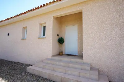 a building with stairs leading to a door with a plant at Villa Clara piscine chauffée in Prunelli-di-Fiumorbo