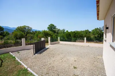 a large patio with a view of the mountains at Villa Clara piscine chauffée in Prunelli-di-Fiumorbo