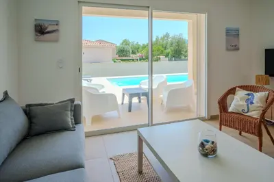a living room with a couch and a table and a pool at Villa Clara piscine chauffée in Prunelli-di-Fiumorbo