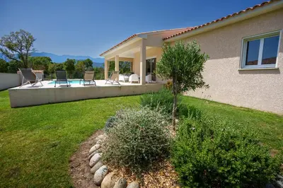 a house with a yard with chairs and a pool at Villa Clara piscine chauffée in Prunelli-di-Fiumorbo
