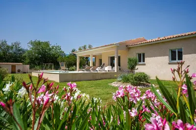 a house with a yard with pink flowers at Villa Camille in Prunelli-di-Fiumorbo