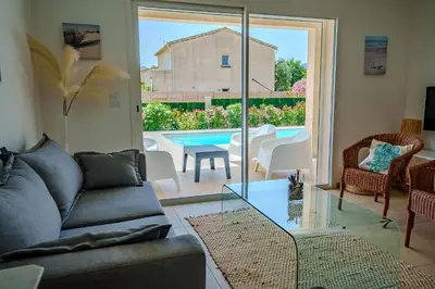 a living room with a couch and a table and a pool at Villa Camille in Prunelli-di-Fiumorbo