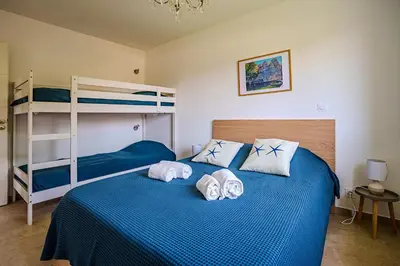 a bedroom with a bed with two bunk beds at Villa Camille in Prunelli-di-Fiumorbo