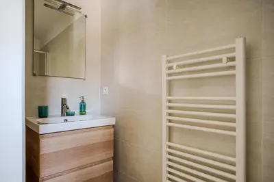 a bathroom with a white sink and a mirror at Villa Camille in Prunelli-di-Fiumorbo
