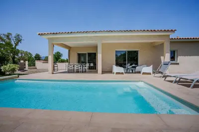 a villa with a swimming pool and a patio at Villa Camille in Prunelli-di-Fiumorbo