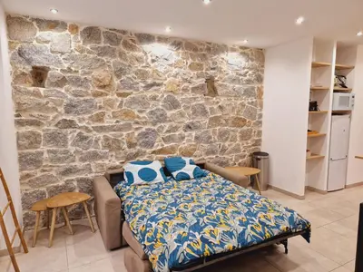 a bedroom with a bed and a stone wall at Superbe appartement en plein coeur d'Ajaccio in Ajaccio