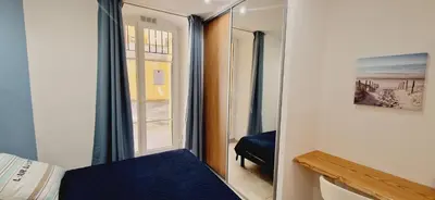 a bedroom with a mirror and a bed and a window at Superbe appartement en plein coeur d'Ajaccio in Ajaccio