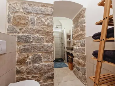 a bathroom with a stone wall at Superbe appartement en plein coeur d'Ajaccio in Ajaccio