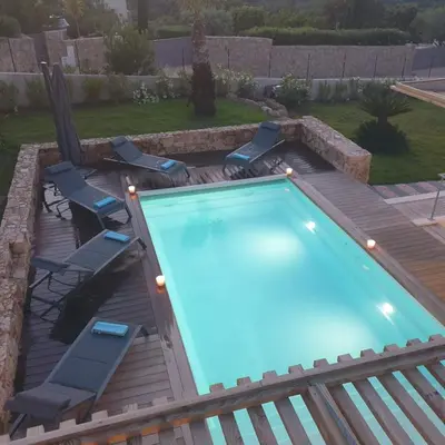 a swimming pool on a deck with chairs around it at Villa Maria 12 pers piscine chauffée 5 min plage en voiture in Sainte-Lucie de Porto-Vecchio