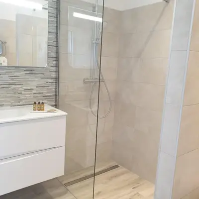 a shower with a glass door in a bathroom at Villa Maria 12 pers piscine chauffée 5 min plage en voiture in Sainte-Lucie de Porto-Vecchio