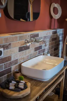 a white sink on a counter with a mirror at Terre de Maquis, maison d'hôtes vue mer Corse in Sari-dʼOrcino