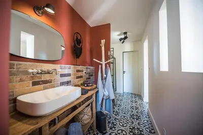 a bathroom with a sink and a mirror at Terre de Maquis, maison d'hôtes vue mer Corse in Sari-dʼOrcino