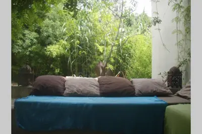 a blue couch with three pillows on it at Grande maison au cadre verdoyant au centre village in Cargèse