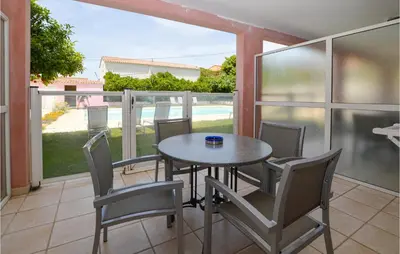 a dining room with a table and chairs on a balcony at Gorgeous Apartment In Propriano in Propriano