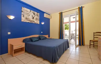 a blue bedroom with a bed and a blue wall at Gorgeous Apartment In Propriano in Propriano