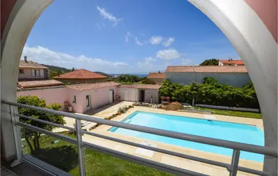a view from the balcony of a villa with a swimming pool at Cozy Apartment In Propriano With Wifi in Propriano