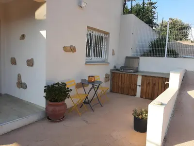 a patio with a table and chairs and a window at Villa_Culomba ALATA -T2 4 couchages in Alata