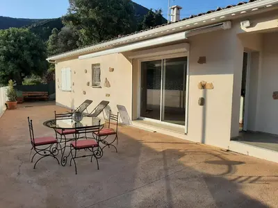 a patio with a table and chairs in front of a house at Villa_Culomba ALATA -T2 4 couchages in Alata
