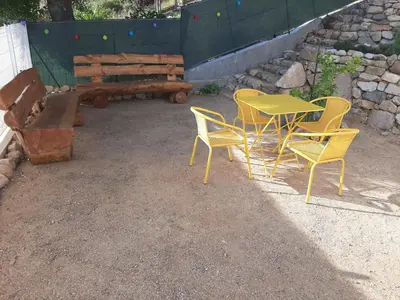 a patio with a table and chairs and a bench at Villa_Culomba ALATA -T2 4 couchages in Alata