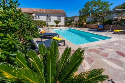 a swimming pool with two chairs and a house at Villa Roma in Prunelli-di-Fiumorbo