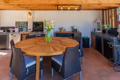 a wooden table with chairs and a vase of flowers on it at Villa Roma in Prunelli-di-Fiumorbo