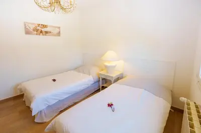two beds in a room with a lamp and flowers on them at Villa Roma in Prunelli-di-Fiumorbo